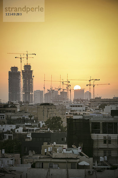 Israel  Tel Aviv  Stadtbild mit Kranichen bei Sonnenuntergang