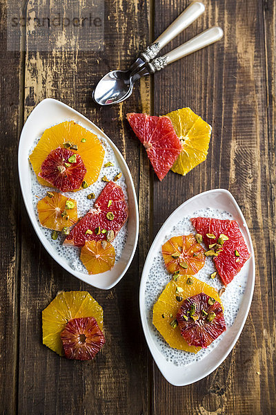Chia Pudding und Scheiben von Orangenblutorange und Grapefruit  Schalen auf Holz