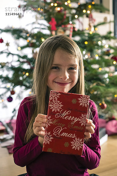 Porträt eines glücklichen Mädchens mit Weihnachtsgeschenk