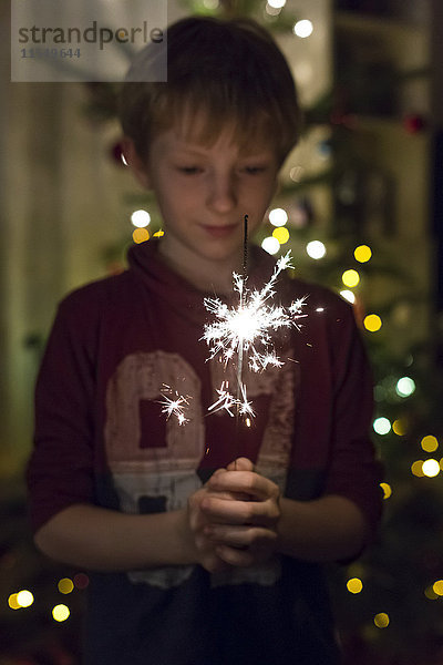 Junge mit Wunderkerze zur Weihnachtszeit