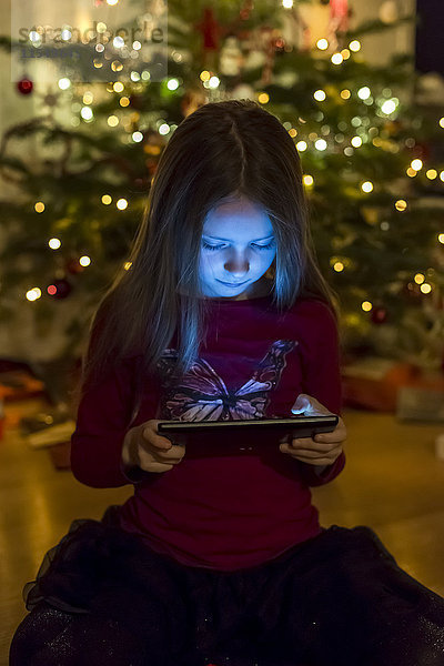 Mädchen beim Betrachten des digitalen Tabletts zur Weihnachtszeit