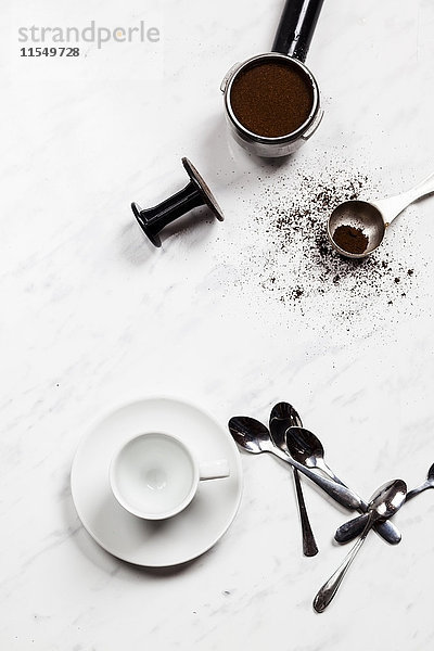 Leere Espressotasse  Löffel und Druckfilter auf weißem Marmor