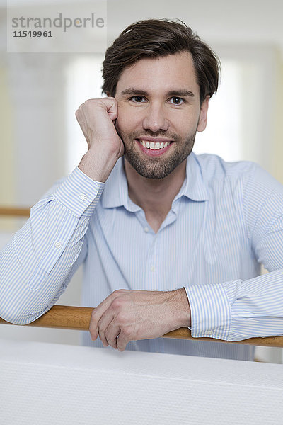 Porträt eines lächelnden Mannes mit braunen Haaren und Bart