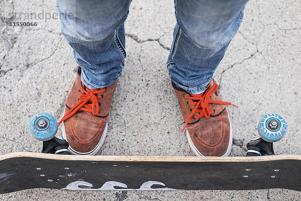 Füße und Beine des Jungen mit Skateboard