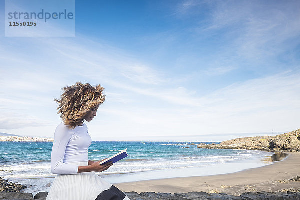 Spanien  Teneriffa  Frau beim Lesen eines Buches in Strandnähe