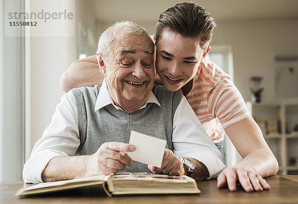 Großvater und Enkel beim gemeinsamen Betrachten alter Fotografien