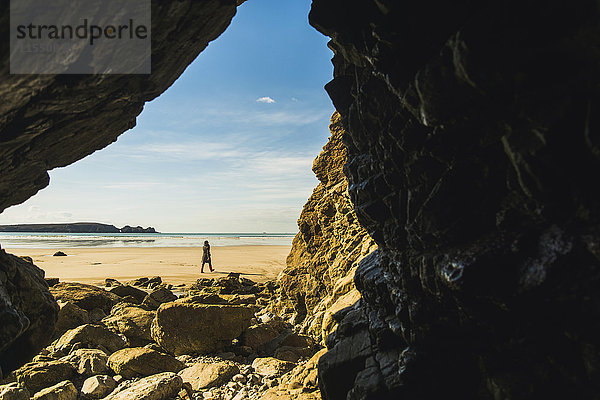 Frankreich  Bretagne  Finistere  Halbinsel Crozon  Frau am Strand von der Felshöhle aus gesehen