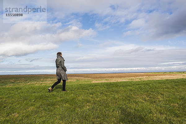Frankreich  Bretagne  Finistere  Halbinsel Crozon  Frau auf einer Wiese an der Küste wandelnd