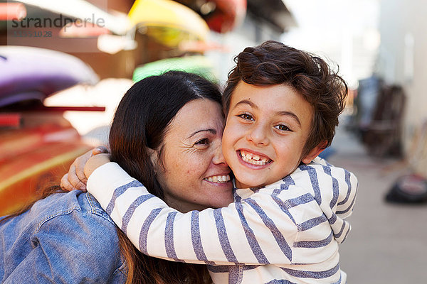 Spanien  Barcelona  Porträt eines glücklichen kleinen Jungen  der seine Mutter umarmt.