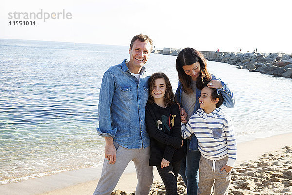 Spanien  Barcelona  Portrait einer glücklichen Familie am Strand