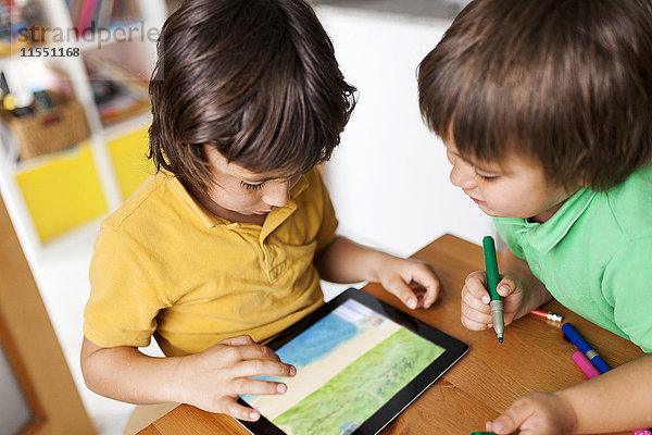 Zwei kleine Brüder spielen mit dem digitalen Tablett
