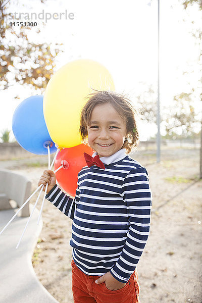 Porträt eines glücklichen kleinen Jungen mit Luftballons