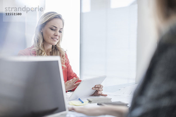 Frau im Büro beim Betrachten des digitalen Tabletts