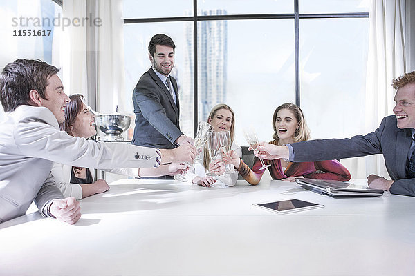 Geschäftsleute feiern den Erfolg im Büro  klirren an den Gläsern