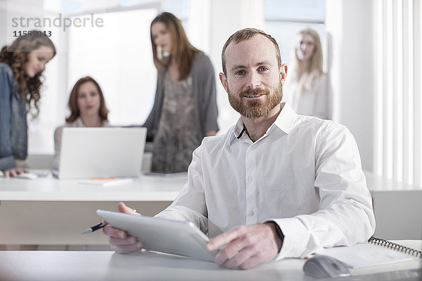Porträt eines selbstbewussten Mannes mit digitalem Tablett im Büro