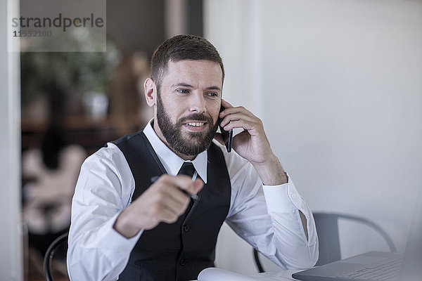 Restaurantleiter im Gespräch am Smartphone