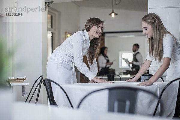 Restaurantmitarbeiter bereiten Tische für den Service vor