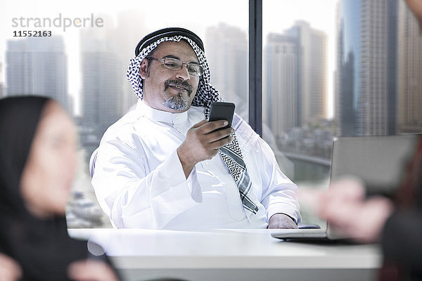 Nahost-Geschäftsmann im Büro mit Smartphone
