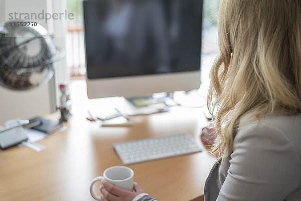 Junge Frau am Schreibtisch im Büro