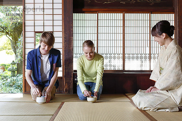 Kaukasisches Paar genießt die Teezeremonie in einem traditionellen japanischen Haus