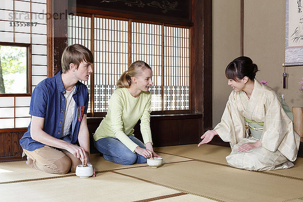 Kaukasisches Paar genießt die Teezeremonie in einem traditionellen japanischen Haus