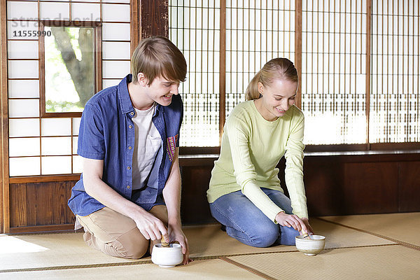 Kaukasisches Paar genießt die Teezeremonie in einem traditionellen japanischen Haus