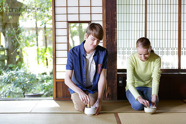 Kaukasisches Paar genießt die Teezeremonie in einem traditionellen japanischen Haus