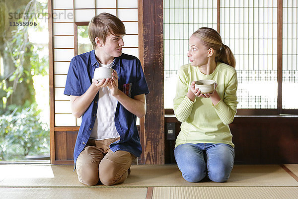 Kaukasisches Paar genießt die Teezeremonie in einem traditionellen japanischen Haus