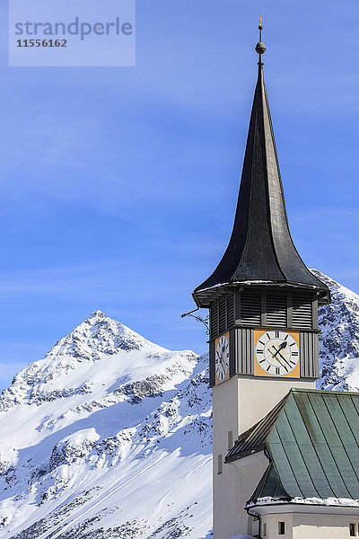 Der typische Alpenglockenturm umrahmt die schneebedeckten Gipfel  Langwies  Bezirk Plessur  Kanton Graubünden  Schweizer Alpen  Schweiz  Europa