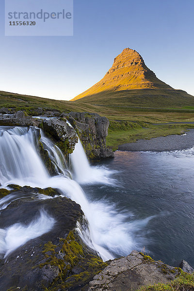 Der Berg Kirkjufell und der Wasserfall Kirkjufoss bei Sonnenuntergang  Halbinsel Snaefellsnes  Island  Polarregionen