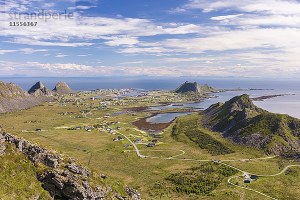 Blick auf das Dorf Sorland  umrahmt von grünen Wiesen und dem Meer  Insel Vaeroy  Bezirk Nordland  Schärengarten der Lofoten  Norwegen  Skandinavien  Europa