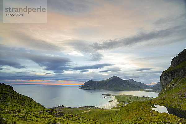 Rosa Wolken der Mitternachtssonne spiegeln sich im kalten Meer  Flakstad  Moskenesoya  Landkreis Nordland  Lofoten  Norwegen  Skandinavien  Europa