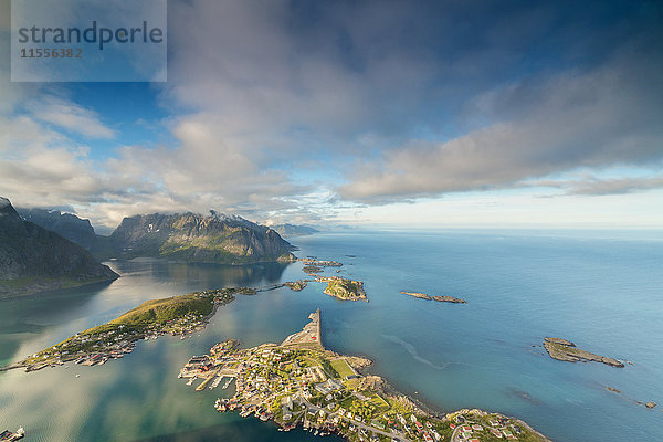 Blauer Himmel und Wolken umrahmen das türkisfarbene Meer und das typische Dorf  Reinebringen  Moskenesoya  Lofoten  Norwegen  Skandinavien  Europa
