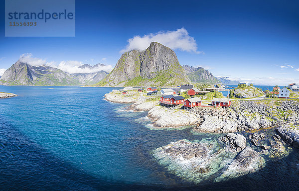 Panorama des Fischerdorfes umrahmt von blauem Meer und hohen Gipfeln  Hamnoy  Moskenesoya  Bezirk Nordland  Lofoten  Norwegen  Skandinavien  Europa