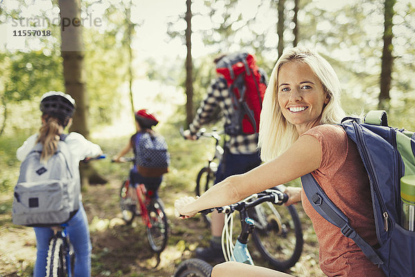 Portrait lächelnde Mutter Mountainbike mit Familie im Wald