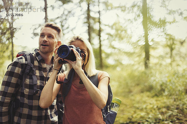 Paar Wandern und Fotografieren von Wäldern mit digitaler Spiegelreflexkamera