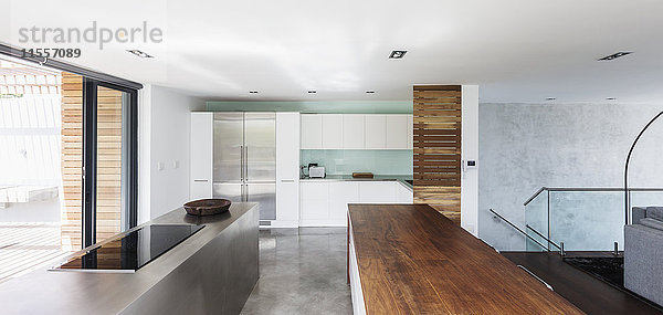 Modernes  minimalistisches Haus mit einer Küche mit Holz- und Edelstahltischen