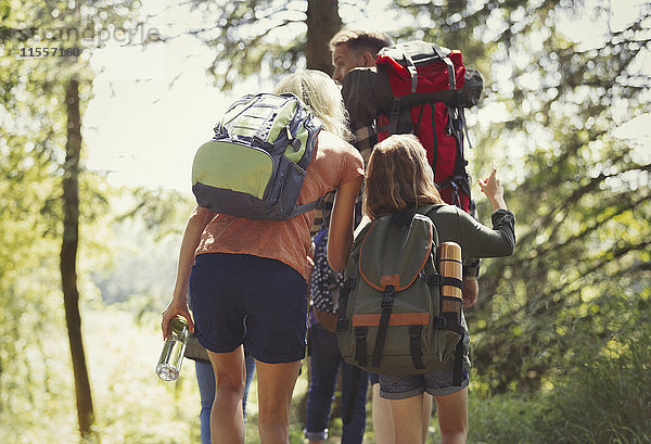 Familie mit Rucksackwandern in sonnigen Wäldern