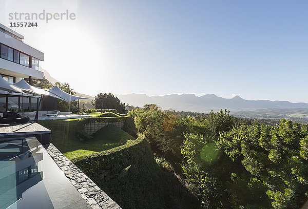 Modernes  luxuriöses Haus mit Außenansicht und Schwimmbad mit sonnigem Bergblick.