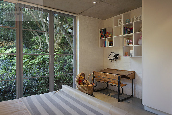 Schreibtisch und Kistenregale in einer Ecke des luxuriösen Kinderzimmers im Schaufenster