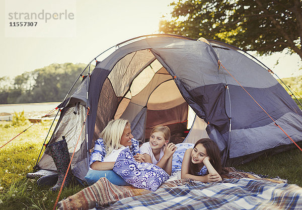 Mutter und Töchter reden und entspannen im Zelt auf dem Campingplatz