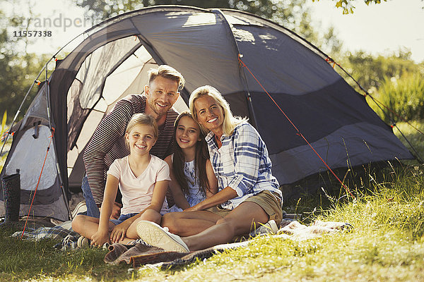 Portrait lächelnde Familie entspannt vor dem sonnigen Campingplatzzelt