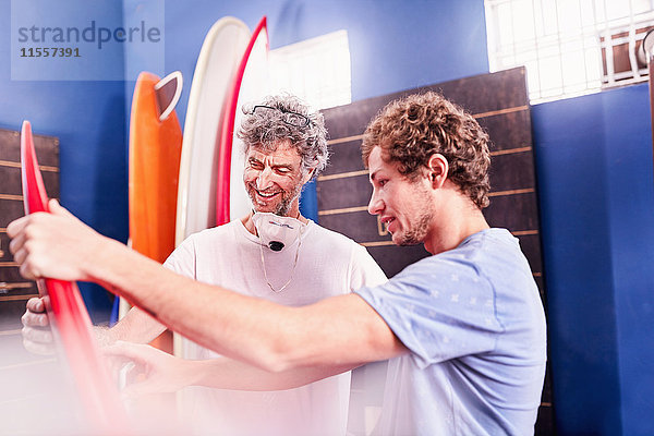 Männer machen und diskutieren Surfbretter im Workshop