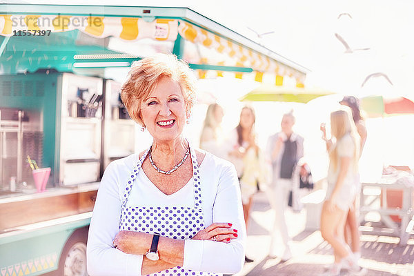 Portrait lächelnde Seniorin Geschäftsinhaberin außerhalb des Speisewagens