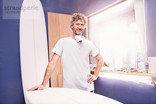 Portrait souveräner Surfbrett-Designer beim Schleifen von Surfbrettern in der Werkstatt