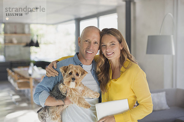 Porträt lächelnd reifen Paar umarmt mit Hund im Wohnzimmer