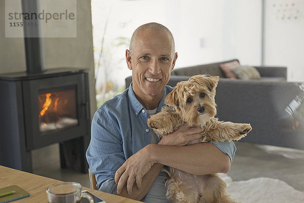 Porträt lächelnd reifen Mann hält niedlichen Hund