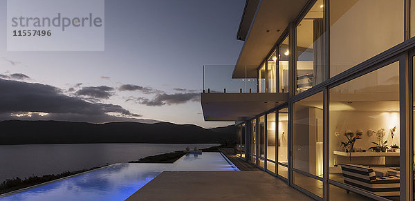 Ruhiges  modernes  luxuriöses Haus mit beleuchtetem Infinity-Pool und Blick aufs Meer
