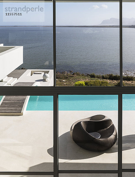 Modernes Luxushaus mit Infinity-Pool im Freien und sonnigem Meerblick