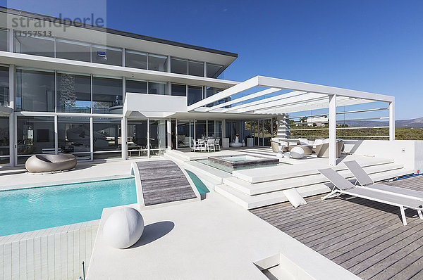 Sonniges  modernes  luxuriöses Haus mit Liegestühlen und Swimmingpool.